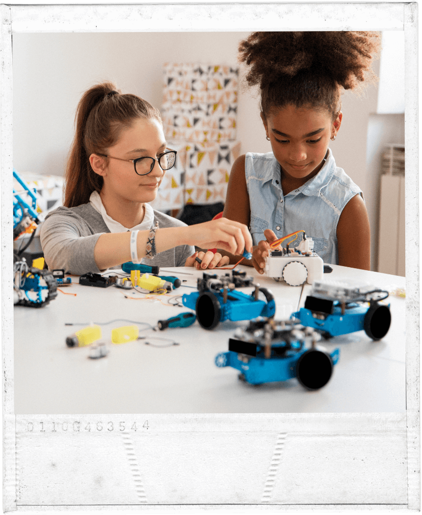 Polaroid mit Schülerinnen welche gemainsam an einem Roboter arbeiten. | make & mint - makerTools